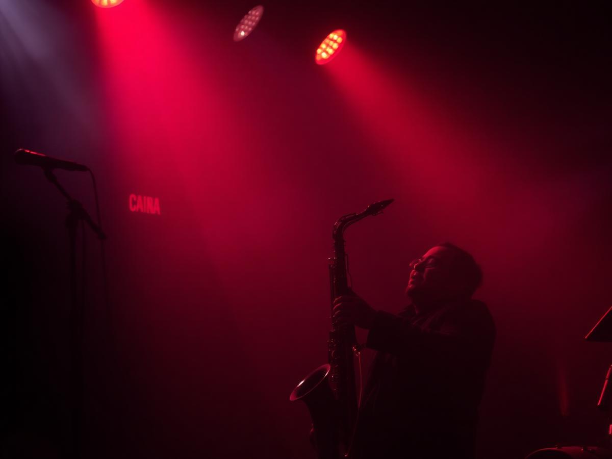 Saxophonist performing under a red spotlight